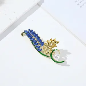Elegant gold wheat brooch with blue crystals and a single white pearl accent