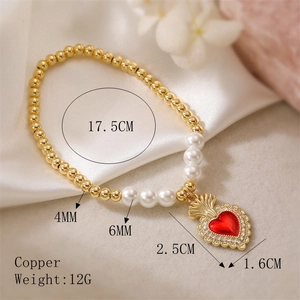 Detail of copper beaded bracelet with white pearl and red zircon heart wing charm