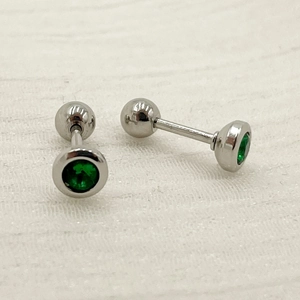 Close-up of green zircon stud earrings with silver threaded ball back fasteners