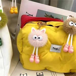 Cute fuzzy coal ball plush keychains in pink and brown with big eyes and small shoes