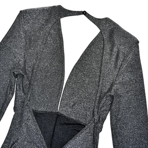 Detail of silver glitter backless jumpsuit featuring a deep V-cut and shimmer fabric texture