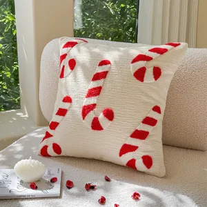 Christmas tufted candy cane cushion on white sherpa sofa with festive decorations