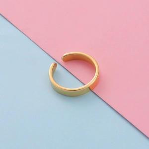 Polished gold adjustable C-shaped ring on a vibrant pastel pink and blue background