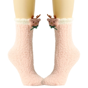 Detail von rosa Korallenvlies-Socken mit 3D-Rentier-Dekor und weißen Umschlägen