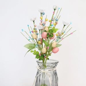 Artificial Easter egg branch with white flowers and berries in a glass vase decor
