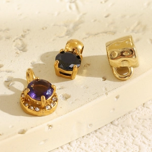 Detailed macro view of 18K gold plated charms with purple and black cubic zirconia stones