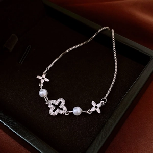 Detailed shot of an adjustable silver flower bracelet with pearls and pavé zircons