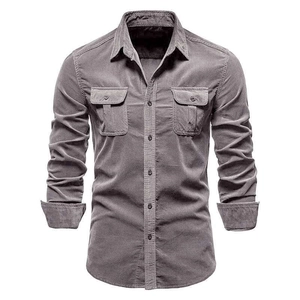 Dettaglio della trama di una camicia di velluto a coste grigio con tasche sul petto