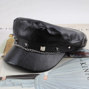 Detail of PU leather newsboy cap showing metal star stud and chain ornament