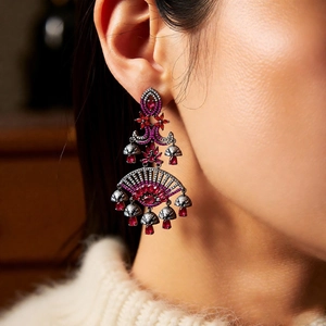 Macro shot of vintage style earrings with red stones on a black gold base