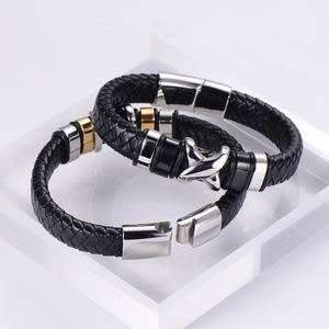 Detail of woven black leather bracelets with silver and gold stainless steel magnetic clasps