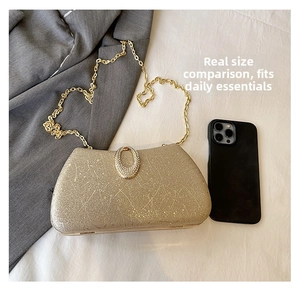 Golden glitter evening bag with rhinestone clasp and chain next to a phone for scale