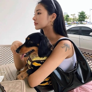 Retro black patent leather crescent shoulder bag styled with a minimalist white outfit