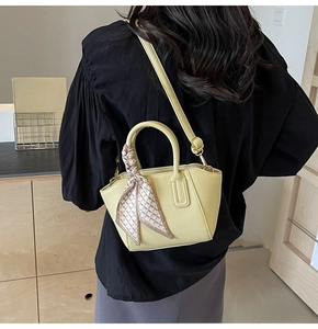 Detail of yellow lychee texture bucket bag with patterned silk scarf and shoulder strap