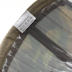 Close-up of 100% acrylic fabric stitching and wash label on a khaki baseball cap