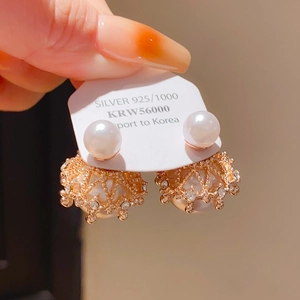 Détail de boucles d'oreilles perles dorées avec boule strass et tige en argent S925
