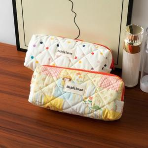 Quilted cotton pencil cases with dots and cartoon patterns on a rustic wooden desk