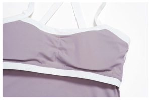 Détail d'un soutien-gorge de sport à bretelles croisées, tissu violet et bords blancs