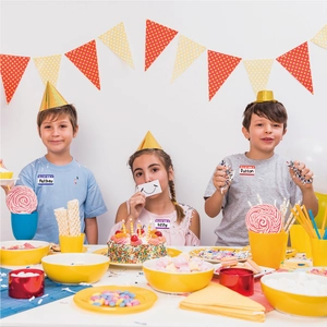 Trois enfants portant des étiquettes de nom imperméables dans une fête colorée