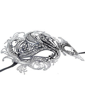Detailed macro view of silver hollowed party mask with glitter and black ribbon ties
