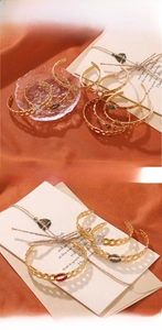 Detail of 18K gold-plated C-shaped bangles with colorful gemstones and star motifs
