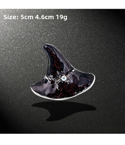 Detail of glittery black witch hat brooch with silver spider and colorful gemstone