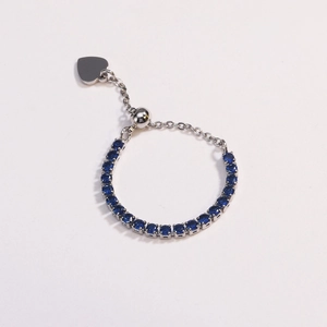 Detail of adjustable silver ring featuring deep blue zircons and a small heart charm
