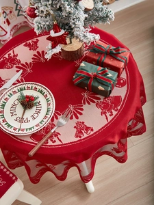 Detail of red Christmas round lace tablecloth featuring reindeer and Santa Claus patterns