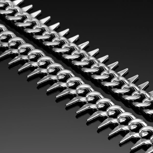 Detailed macro view of 20mm silver-tone spiked Cuban chain links on black reflective surface