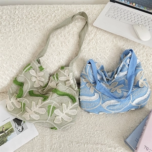 Dettaglio del ricamo floreale 3D e delle nappe sulla borsa tote in tela di cotone