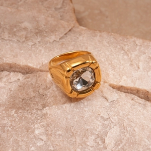 Macro detail of a vintage gold ring featuring a large zircon stone on a natural rock base