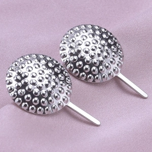 Macro shot of silver 304 stainless steel round earrings with embossed dot texture