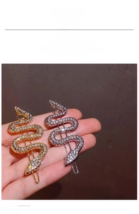 Detailed view of snake-shaped hair clips with sparkling rhinestones in gold and silver