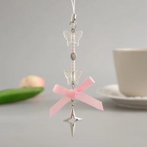 Detailed shot of cute strawberry keychain with pink bow and silver heart charms