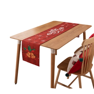 Christmas table runner with red snowflakes and Merry Christmas bells on wooden table