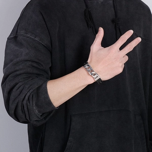 Detail of men's black braided leather bracelet with a silver stainless steel Cuban link