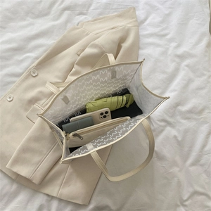Large beige transparent tote bag with M-pattern print showing spacious interior capacity