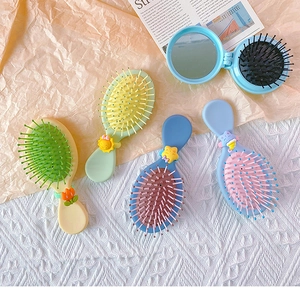 Detail of pastel candy-colored air cushion brushes and round mirror comb set for hair styling