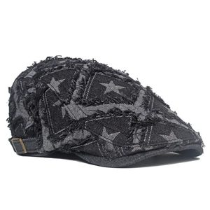 Détail d'un béret en denim gris foncé vieilli avec bords effilochés et motifs d'étoiles