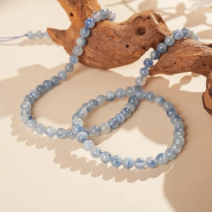 Macro shot of blue kyanite beaded bracelet on a decorative weathered wood stand