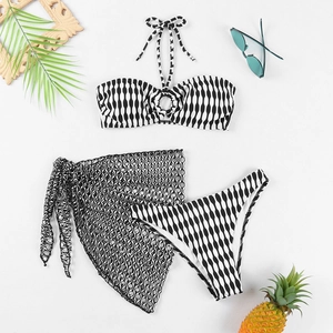 Détail d'un bikini 3 pièces à motif vagues noir et blanc avec paréo en résille ajourée