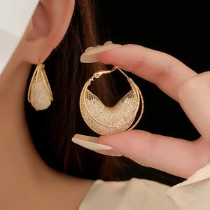 Detail von goldenen Netz-Ohrringen mit weißen Perlen, Nahaufnahme Modeschmuck-Präsentation