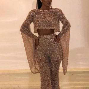 Detail of sequin two-piece set featuring long flare sleeves and high-waist wide-leg pants