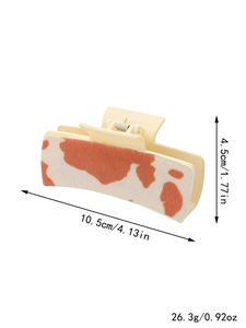 Detail view of large cow print hair claw clip showing 10.5cm length and product weight