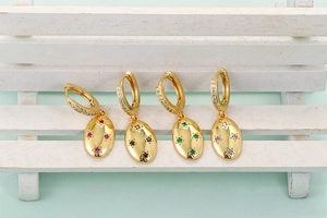 Detail of star oval earrings with colorful zircon in red, black, green and purple