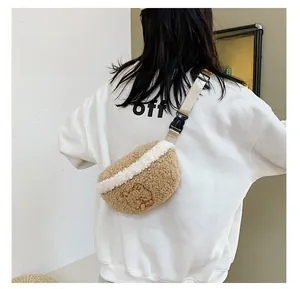 Detail view of brown faux fur waist bag with cartoon bear embroidery and buckle strap