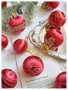 Detail einer roten Seiden-Weihnachtskugel mit goldenen Pailletten und Perlenverzierung