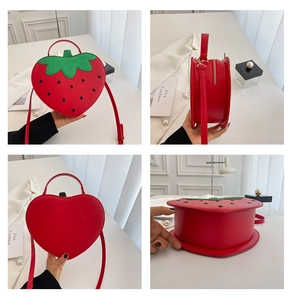 Macro details of red strawberry heart bag showing PU leather texture and green leaf design