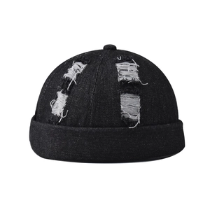 Detail of black washed denim docker hat showing distressed edges and ripped fabric texture