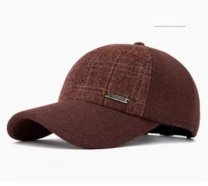 Détail de la casquette d'hiver bordeaux à carreaux avec cache-oreilles et logo en métal
